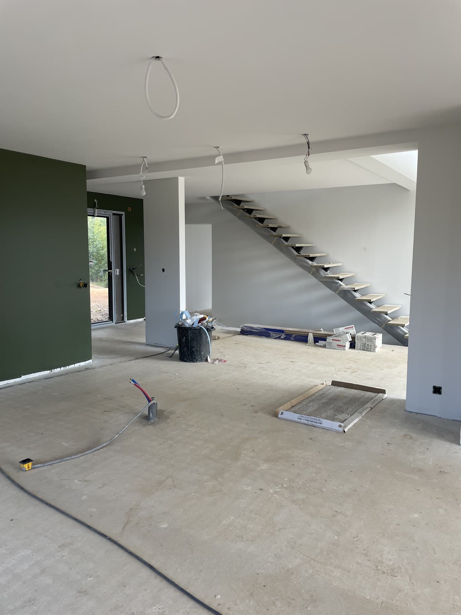 Mezzanine et escalier, mur vert profond et sols bâchés