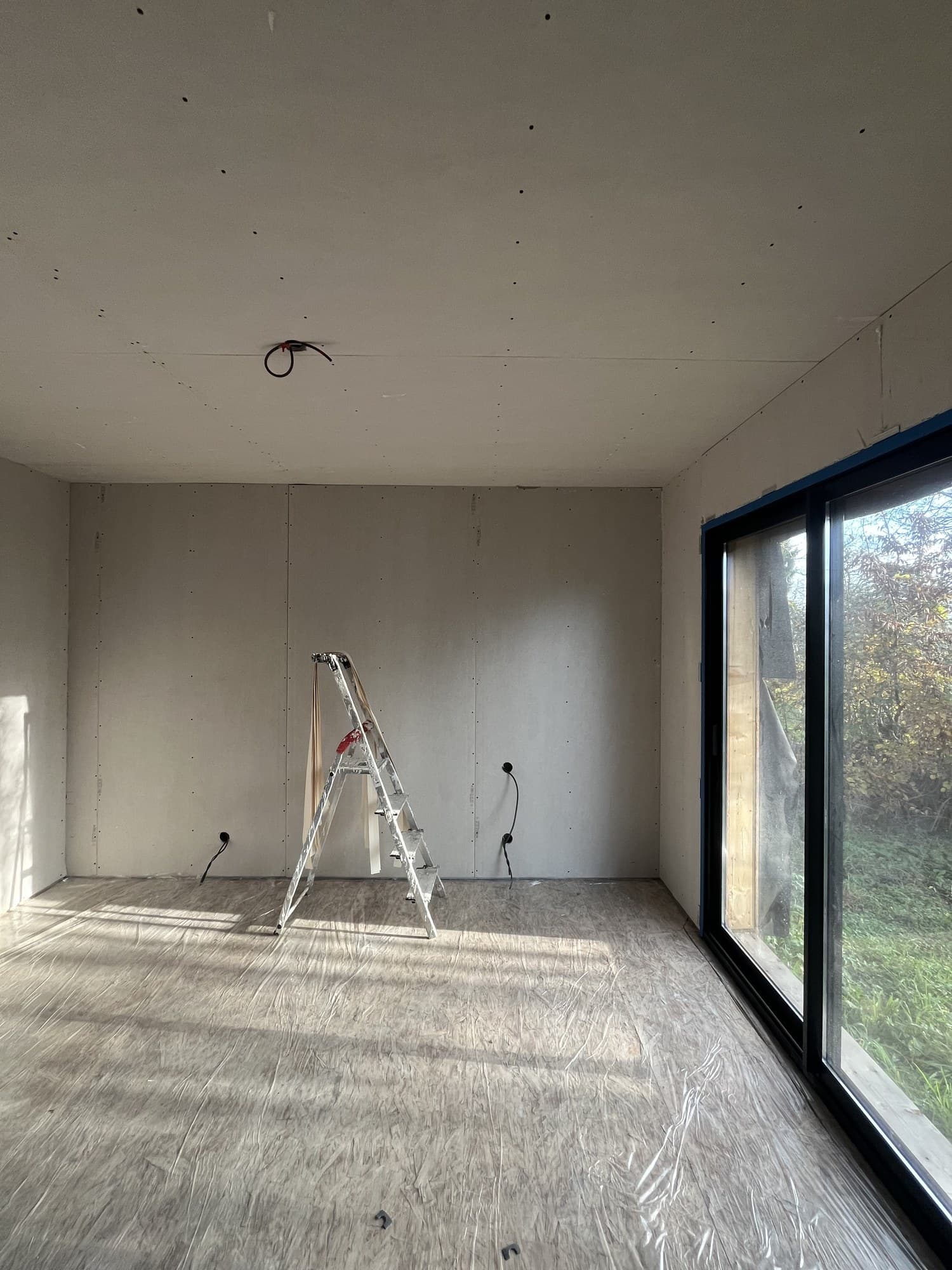 Pièce ouverte sur une grande baie vitrée, sol intégralement protégé pendant les travaux